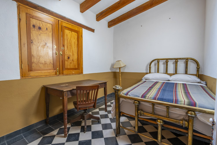 furnished bedroom with brass bed and tile floor