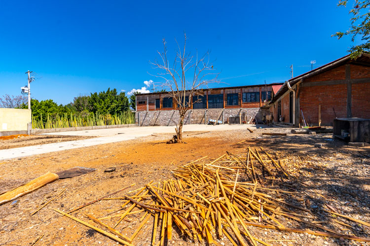 exterior behind restaurant in front of agave maguey fields with additional parking