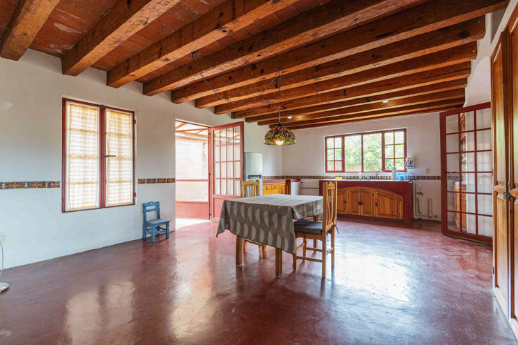 dining room with wooden beamed ceiling and natural light from windows