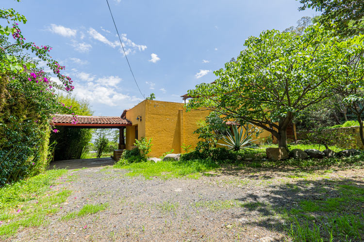 front yard and parking structure with spanish tile roof