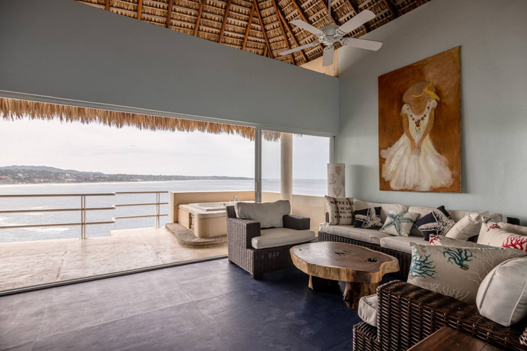 living room with ceiling fan palapa palm roof and ocean view