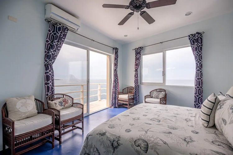 bedroom with bed ceiling fan and two windows