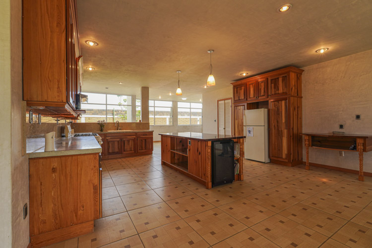 kitchen with island countertop and hand built wood and glass cabinets