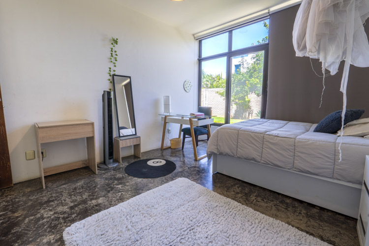 bedroom with white wall and large window facing lawn