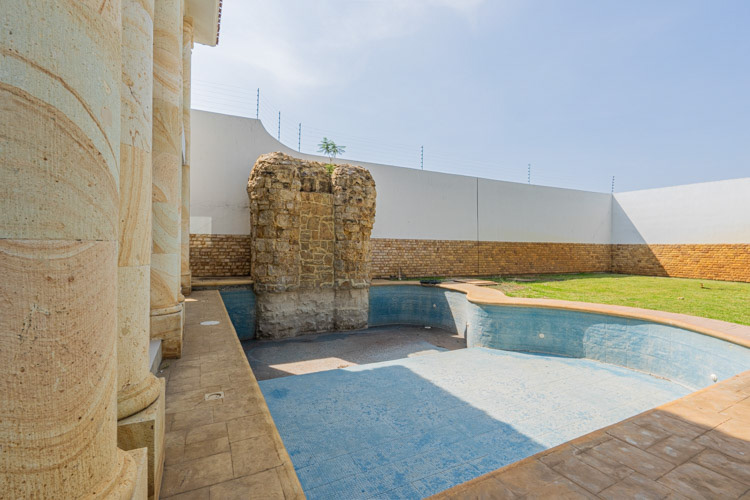 deep swimming pool with rock waterfall and bathroom changing room