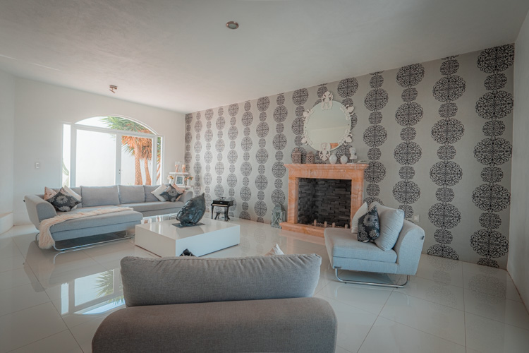 living room with french wallpaper and fireplace with natural light from big window