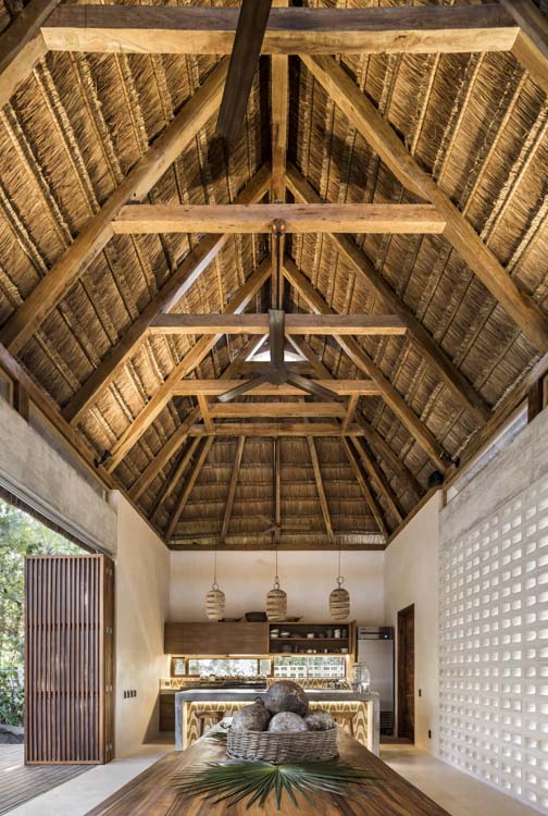 eco chic cabin interior with wooden roof and high ceiling in Tulum