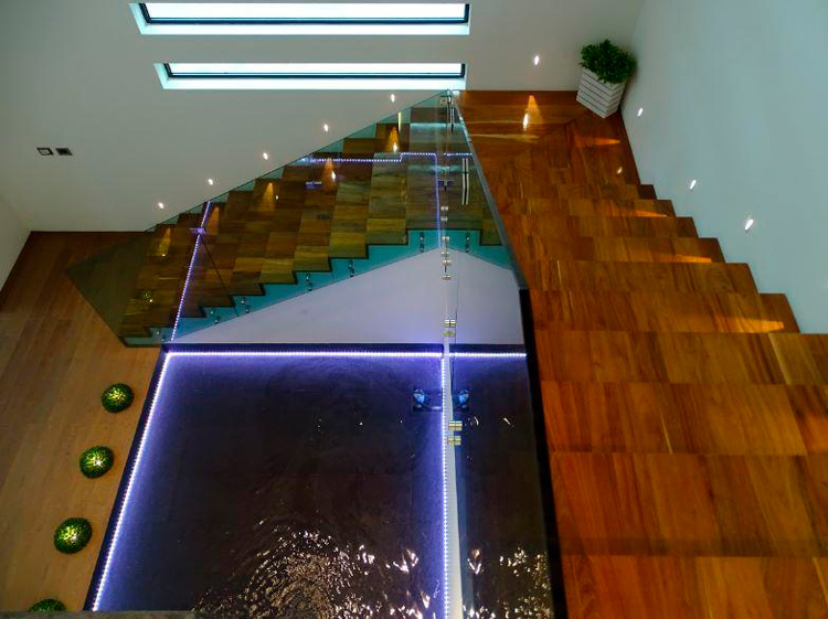 stairwell with glass bannister and reflecting pool